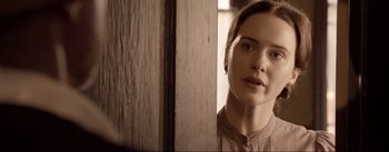 Movie still from “Dead for a Dollar” (2022), directed by Walter Hill – A woman is standing in a room looking at the camera; Close Up shot, Over the shoulder angle