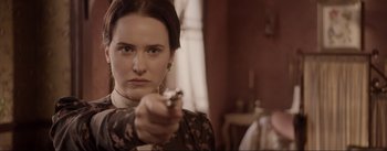 Movie still from “Dead for a Dollar” (2022), directed by Walter Hill – A beautiful woman holding a gun in a room; Close Up shot, Over the shoulder angle