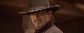 Movie still from “Dead for a Dollar” (2022), directed by Walter Hill – A person wearing a hat; Close Up shot, Over the shoulder angle