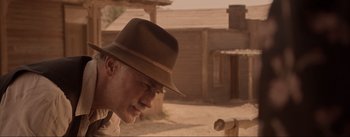 Movie still from “Dead for a Dollar” (2022), directed by Walter Hill – An old man wearing a brown hat looking down; Close Up shot, Low angle