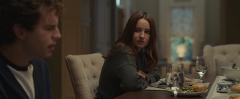 Movie still from “Dear Evan Hansen” (2021), directed by Stephen Chbosky – A woman sitting at a table with her arms crossed; Medium shot, Over the shoulder angle