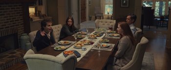 Movie still from “Dear Evan Hansen” (2021), directed by Stephen Chbosky – A group of people sitting around a table with plates of food; Wide shot, High angle