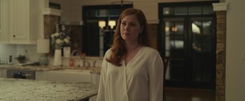 Movie still from “Dear Evan Hansen” (2021), directed by Stephen Chbosky – A woman standing in front of a sink in a room; Medium shot, Over the shoulder angle