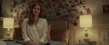 Movie still from “Dear Evan Hansen” (2021), directed by Stephen Chbosky – A woman sitting on a bed in front of a wall covered with pictures; Medium shot, Over the shoulder angle