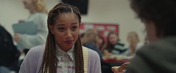 Movie still from “Dear Evan Hansen” (2021), directed by Stephen Chbosky – A young woman with long braids wearing a shirt and cardigan; Close Up shot, Over the shoulder angle