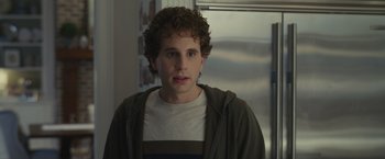 Movie still from “Dear Evan Hansen” (2021), directed by Stephen Chbosky – A young man with curly brown hair wearing a white t - shirt; Close Up shot, Over the shoulder angle