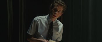 Movie still from “Dear Evan Hansen” (2021), directed by Stephen Chbosky – A man in a tie holding a piece of paper in his hands; Medium shot, Low angle