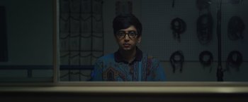 Movie still from “Dear Evan Hansen” (2021), directed by Stephen Chbosky – A man with glasses sitting in front of a computer monitor; Medium shot, Overhead angle