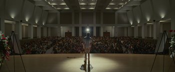 Movie still from “Dear Evan Hansen” (2021), directed by Stephen Chbosky – A man standing in front of an audience on a stage; Extreme Wide shot, Low angle