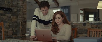 Movie still from “Dear Evan Hansen” (2021), directed by Stephen Chbosky – A man and a woman looking at a laptop computer; Medium shot, Over the shoulder angle