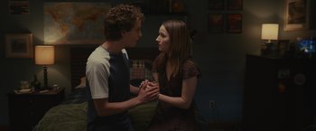 Movie still from “Dear Evan Hansen” (2021), directed by Stephen Chbosky – A man and a woman holding hands in a living room; Medium shot, Over the shoulder angle