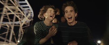 Movie still from “Dear Evan Hansen” (2021), directed by Stephen Chbosky – A man and a woman laughing together in a theater; Medium shot, Over the shoulder angle