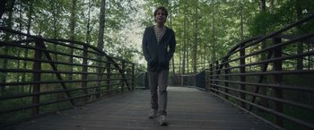 Movie still from “Dear Evan Hansen” (2021), directed by Stephen Chbosky – A man walking across a bridge in the woods; Wide shot, Low angle