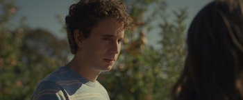 Movie still from “Dear Evan Hansen” (2021), directed by Stephen Chbosky – A young man with curly brown hair looking to his left; Close Up shot, Low angle