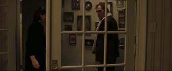 Movie still from “Two Lovers” (2008), directed by James Gray – A man standing in front of a window looking out; Medium shot, Over the shoulder angle