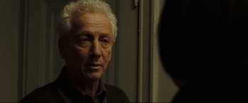 Movie still from “Two Lovers” (2008), directed by James Gray – An older man looking at the camera in front of a mirror; Close Up shot, Over the shoulder angle