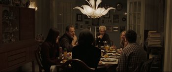 Movie still from “Two Lovers” (2008), directed by James Gray – A group of people sitting around a dinner table; Wide shot, Over the shoulder angle