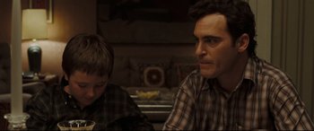 Movie still from “Two Lovers” (2008), directed by James Gray – A man sitting next to a boy in a kitchen; Close Up shot, Over the shoulder angle