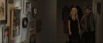 Movie still from “Two Lovers” (2008), directed by James Gray – A woman standing in a room next to a mirror; Medium shot, Over the shoulder angle