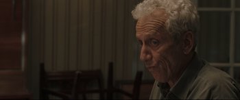 Movie still from “Two Lovers” (2008), directed by James Gray – An older man with white curly hair and blue eyes; Close Up shot, Over the shoulder angle