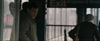 Movie still from “Two Lovers” (2008), directed by James Gray – A man standing in front of a metal fence; Medium shot, Over the shoulder angle