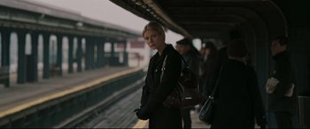Movie still from “Two Lovers” (2008), directed by James Gray – A woman standing on a train platform waiting for a train to arrive; Medium shot, Over the shoulder angle