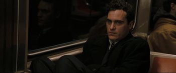 Movie still from “Two Lovers” (2008), directed by James Gray – A man in a suit sitting on a train; Close Up shot, Over the shoulder angle