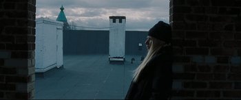 Movie still from “Two Lovers” (2008), directed by James Gray – A woman standing on top of a building looking at the sky; Medium shot, Low angle