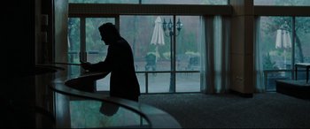 Movie still from “Two Lovers” (2008), directed by James Gray – A man standing in front of a large window; Wide shot, Over the shoulder angle