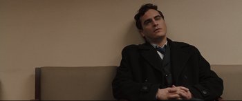 Movie still from “Two Lovers” (2008), directed by James Gray – A man sitting on a bench with his head resting on his arms; Close Up shot, Low angle