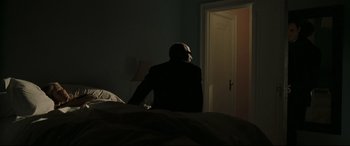 Movie still from “Two Lovers” (2008), directed by James Gray – A man standing in the dark in front of a door; Medium shot, Over the shoulder angle