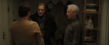 Movie still from “Two Lovers” (2008), directed by James Gray – Two older men standing next to each other in a room; Medium shot, Over the shoulder angle