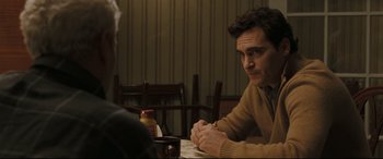 Movie still from “Two Lovers” (2008), directed by James Gray – A man sitting at a table in a restaurant; Medium shot, Over the shoulder angle