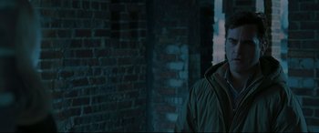 Movie still from “Two Lovers” (2008), directed by James Gray – A man standing in front of a brick wall; Close Up shot, Over the shoulder angle