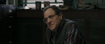 Movie still from “Two Lovers” (2008), directed by James Gray – An older man wearing glasses sitting in front of a window; Close Up shot, Over the shoulder angle