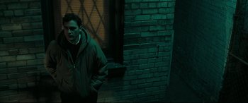 Movie still from “Two Lovers” (2008), directed by James Gray – A man standing in front of a brick wall; Medium shot, High angle