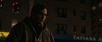 Movie still from “Two Lovers” (2008), directed by James Gray – A man standing in the dark in front of a building; Close Up shot, Over the shoulder angle