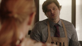 Movie still from “Deborah” (2022), directed by Noga Pnueli – A man wearing an apron looking in a mirror; Close Up shot, Over the shoulder angle