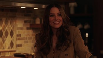 Movie still from “Deborah” (2022), directed by Noga Pnueli – A woman with long brown hair smiling for the camera; Close Up shot, Over the shoulder angle
