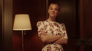 Movie still from “Deborah” (2022), directed by Noga Pnueli – A woman standing in front of a lamp in a dimly - lit room; Medium shot, Low angle