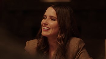 Movie still from “Deborah” (2022), directed by Noga Pnueli – A woman with long brown hair smiling at the camera; Close Up shot, Over the shoulder angle