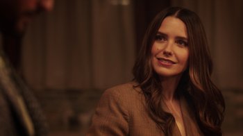 Movie still from “Deborah” (2022), directed by Noga Pnueli – A woman in a brown jacket is smiling for the camera; Close Up shot, Over the shoulder angle