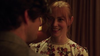 Movie still from “Deborah” (2022), directed by Noga Pnueli – A young woman smiles at the camera as a young man looks on; Close Up shot, Over the shoulder angle