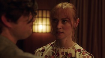 Movie still from “Deborah” (2022), directed by Noga Pnueli – A woman in a floral dress looking at a man in front of a mirror; Close Up shot, Over the shoulder angle
