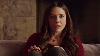 Movie still from “Deborah” (2022), directed by Noga Pnueli – A woman sitting on a couch looking at the camera; Close Up shot, Over the shoulder angle