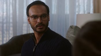 Movie still from “Deborah” (2022), directed by Noga Pnueli – A person wearing glasses and a sweater; Close Up shot, Over the shoulder angle