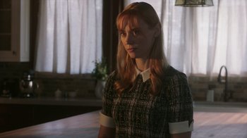 Movie still from “Deborah” (2022), directed by Noga Pnueli – A woman with red hair wearing a black and white dress; Medium shot, Over the shoulder angle