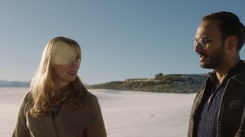 Movie still from “Deborah” (2022), directed by Noga Pnueli – A woman standing on top of a sandy beach next to the ocean; Medium shot, Over the shoulder angle