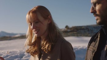 Movie still from “Deborah” (2022), directed by Noga Pnueli – A woman with red hair standing in the snow; Close Up shot, Over the shoulder angle