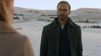 Movie still from “Deborah” (2022), directed by Noga Pnueli – A man with a beard and glasses standing in front of a woman; Close Up shot, Over the shoulder angle